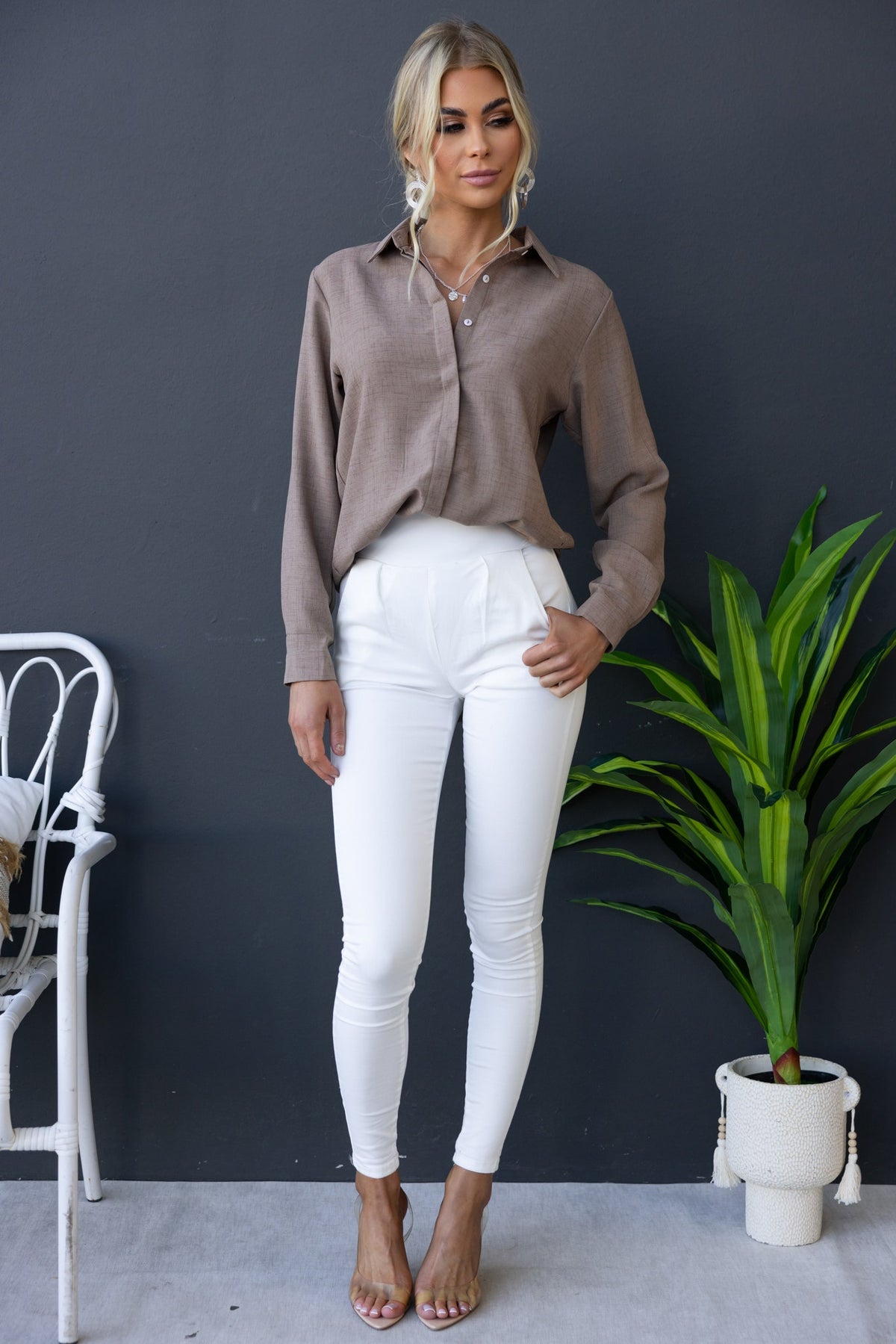 Model wearing beige Toomba Shirt with white pants, casual style, featuring button-up front and relaxed fit.