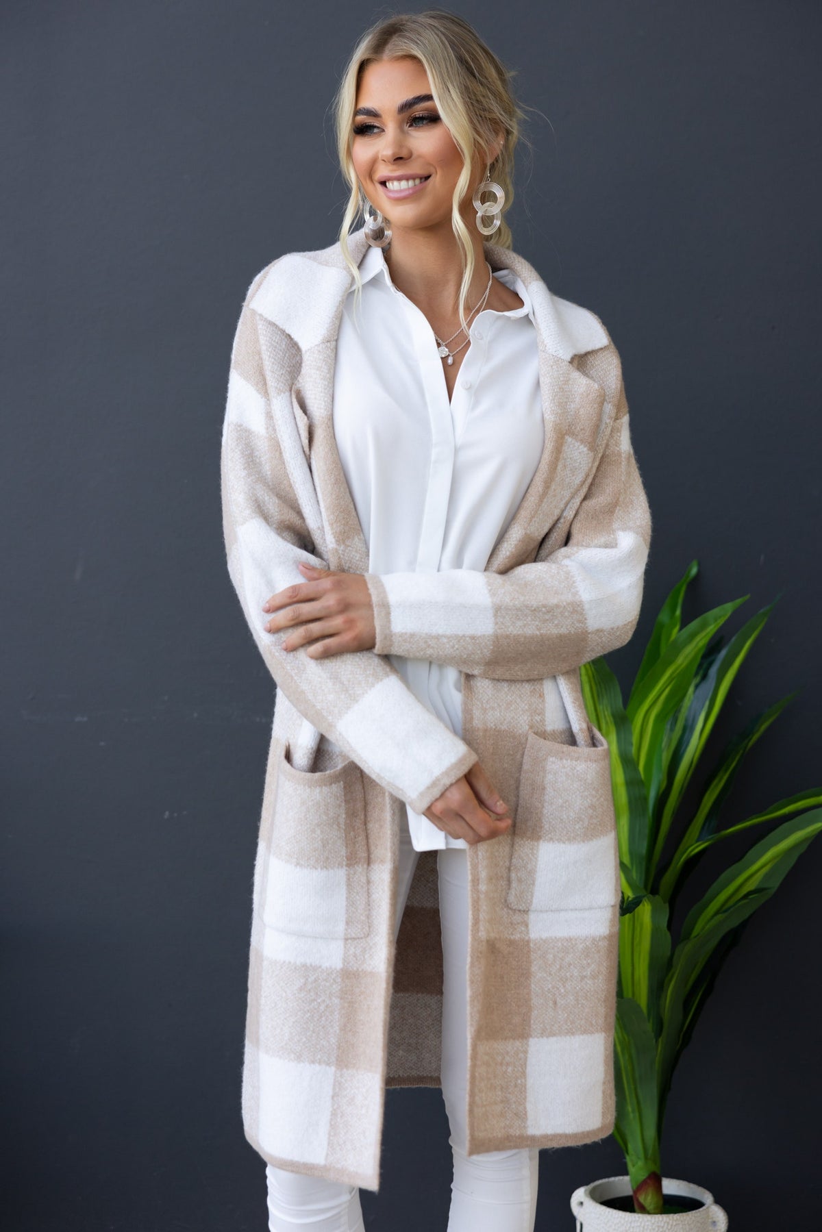 Model wearing a longline Fatale cardigan with collar and lapel, featuring a plaid design and front pockets.