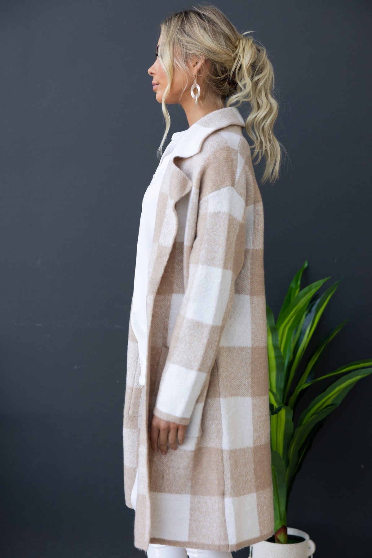 Side view of a model in a longline Fatale cardigan featuring a checked pattern and pockets.