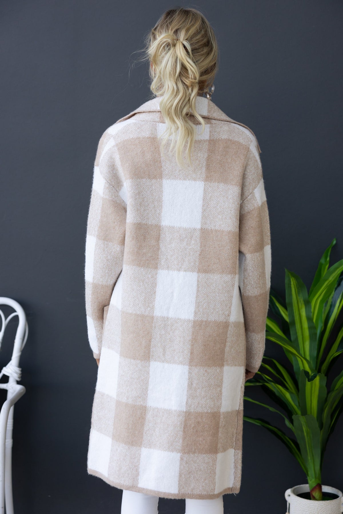 Back view of the Fatale Cardigan in a beige and white plaid pattern, featuring a longline fit and collar.