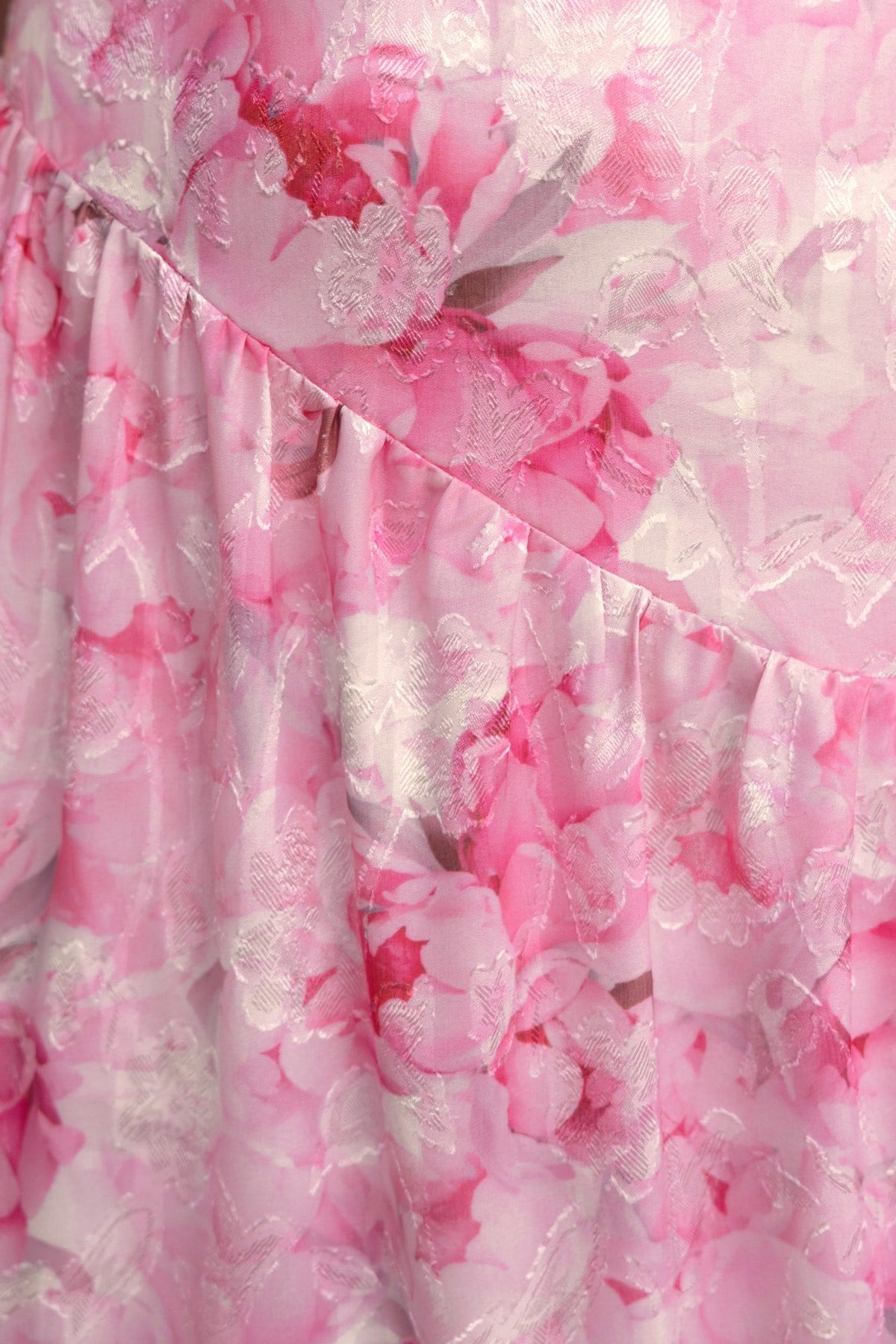 Close-up of pink floral fabric with textured detailing in the Asja Maxi Dress.