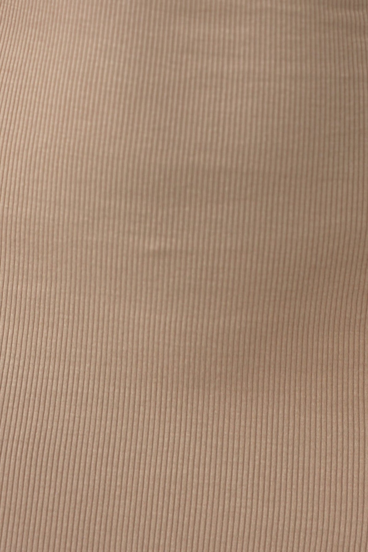 Close-up of ribbed fabric in a soft beige color, showcasing texture and stretch for a stylish midi dress.