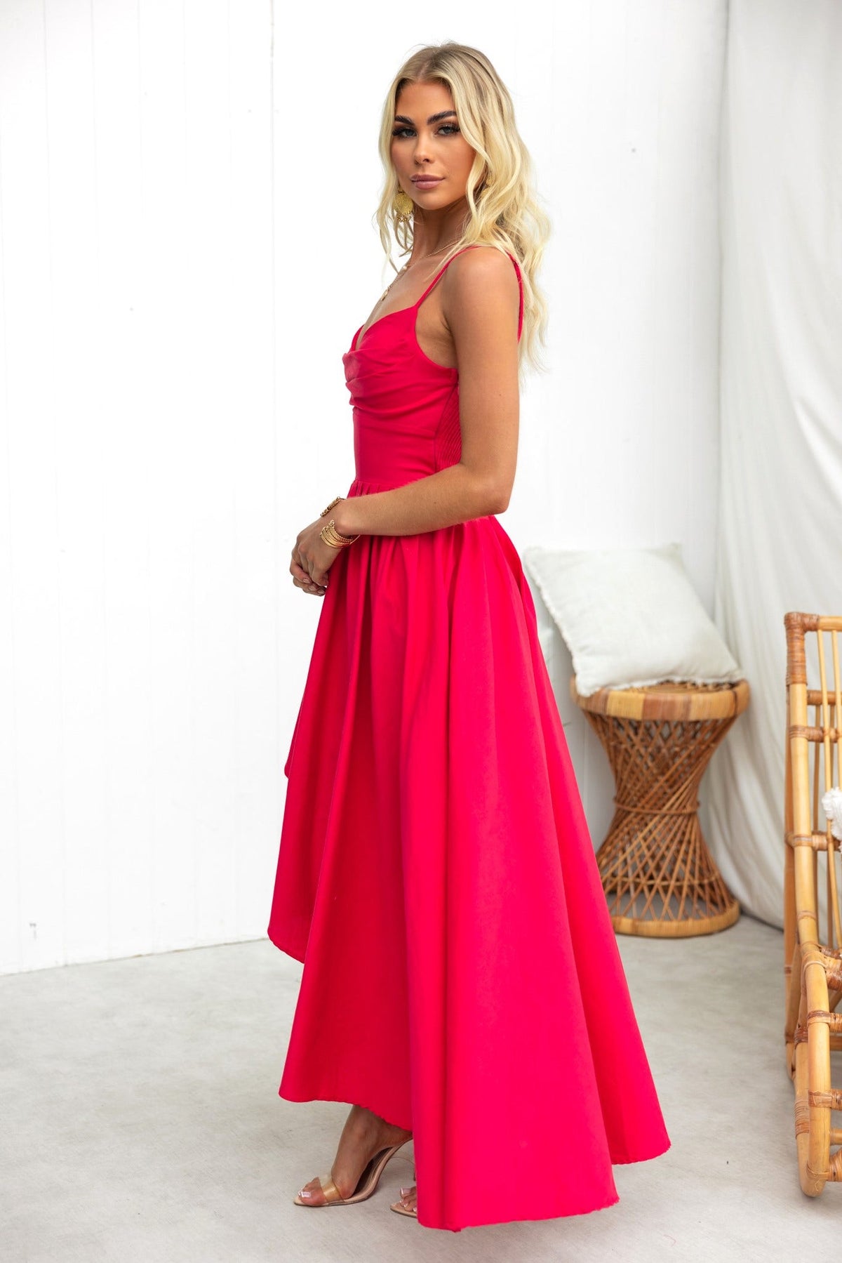 Side view of the Adalita Maxi Dress in vibrant pink, featuring adjustable straps and a flowing asymmetrical hemline.