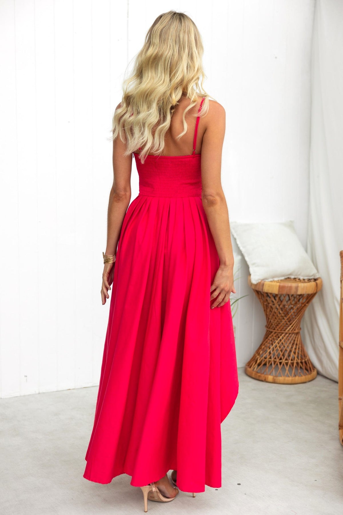 Adalita Maxi Dress in bright pink with adjustable straps and asymmetrical hemline, shown from the back.