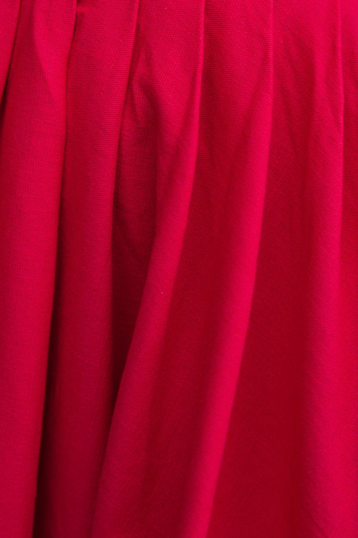 Close-up of vibrant red fabric showcasing the texture of the Adalita Maxi Dress, highlighting its cotton look.