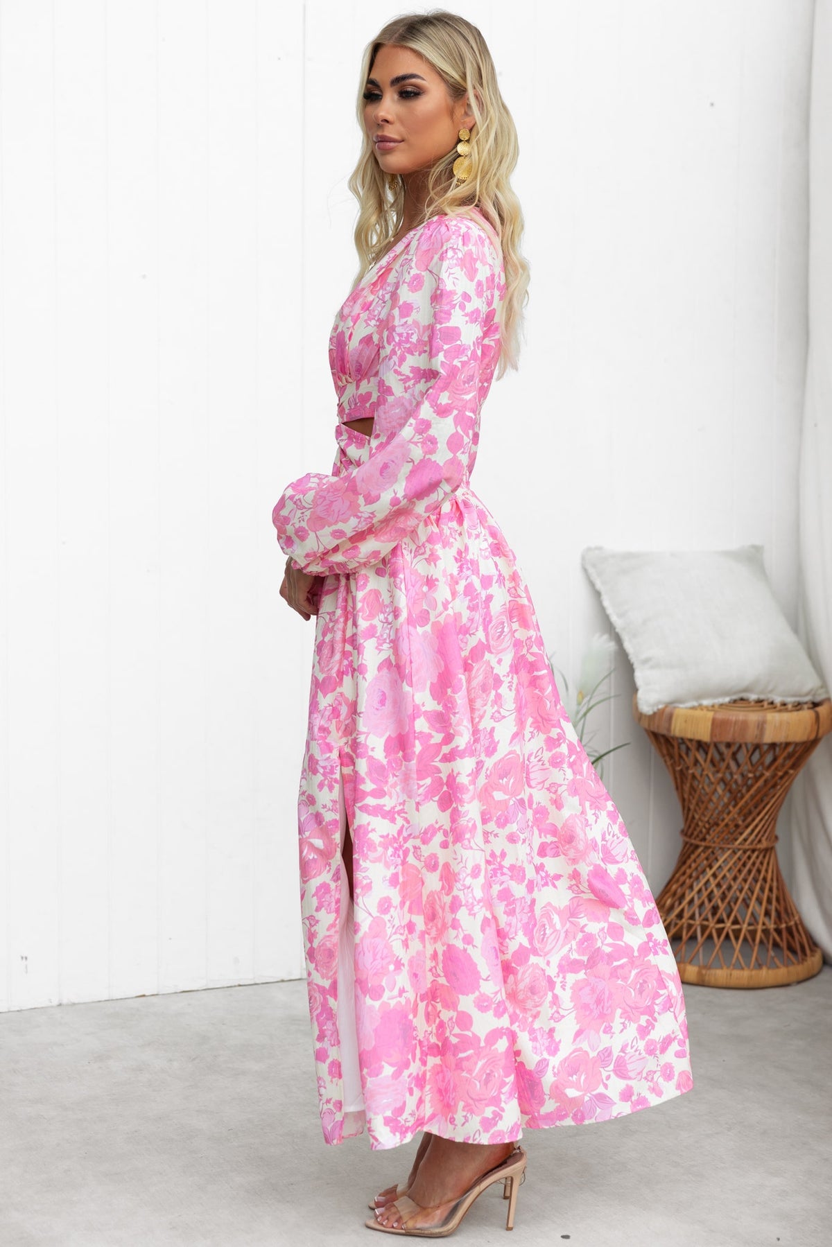Model wearing a pink floral maxi dress with a plunge neckline and cut-out waist details.