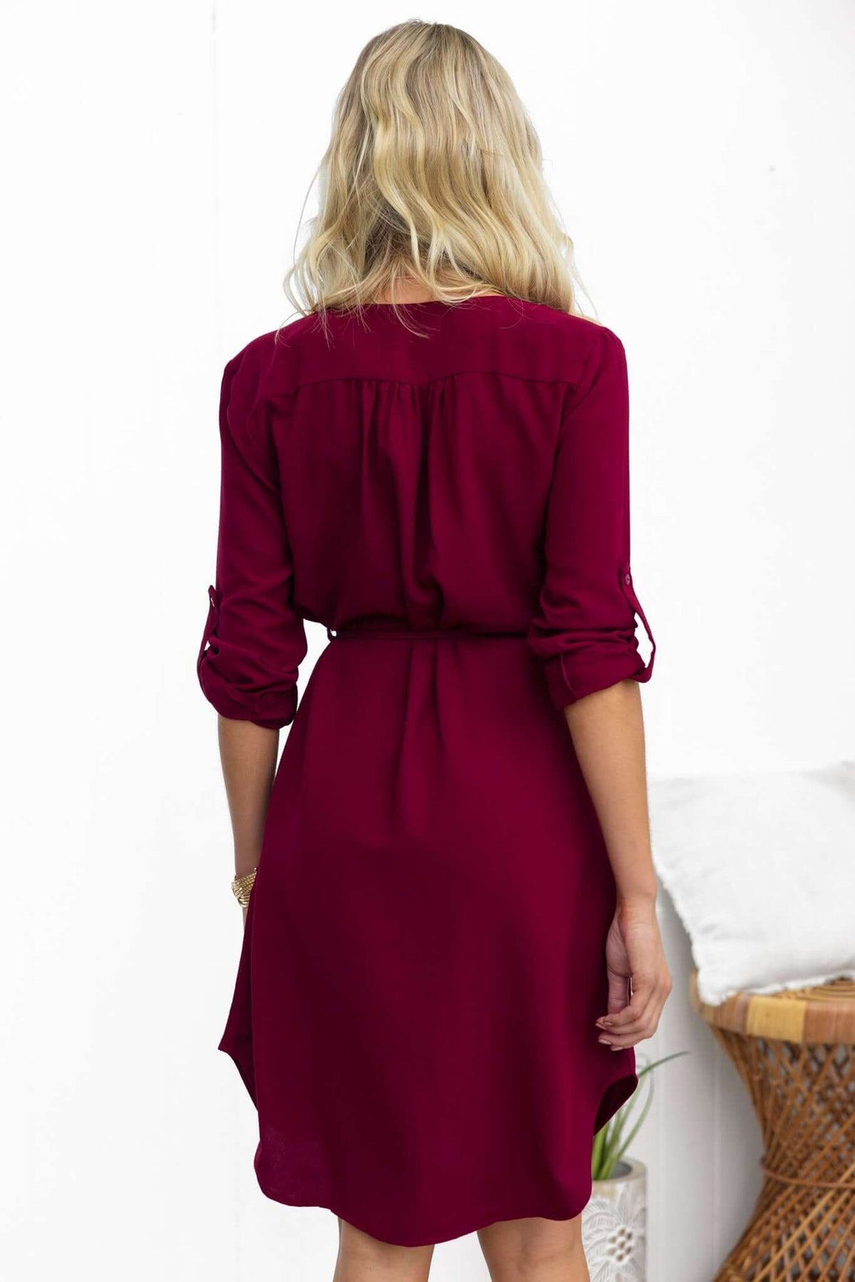 Back view of the Deklyn Dress in burgundy with rolled sleeves and a tie belt, perfect for casual outings.