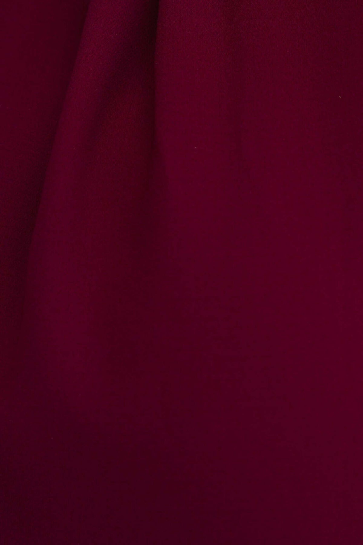 Close-up of rich burgundy fabric texture of the Deklyn Dress, showcasing its soft drape and color.