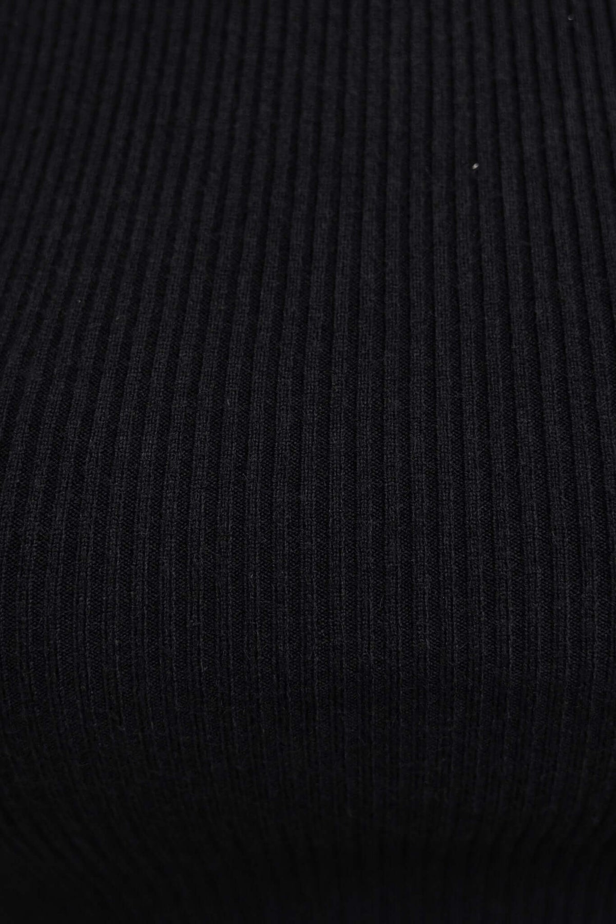 Close-up of black ribbed knit fabric for Nowlan Top, showcasing texture and quality.