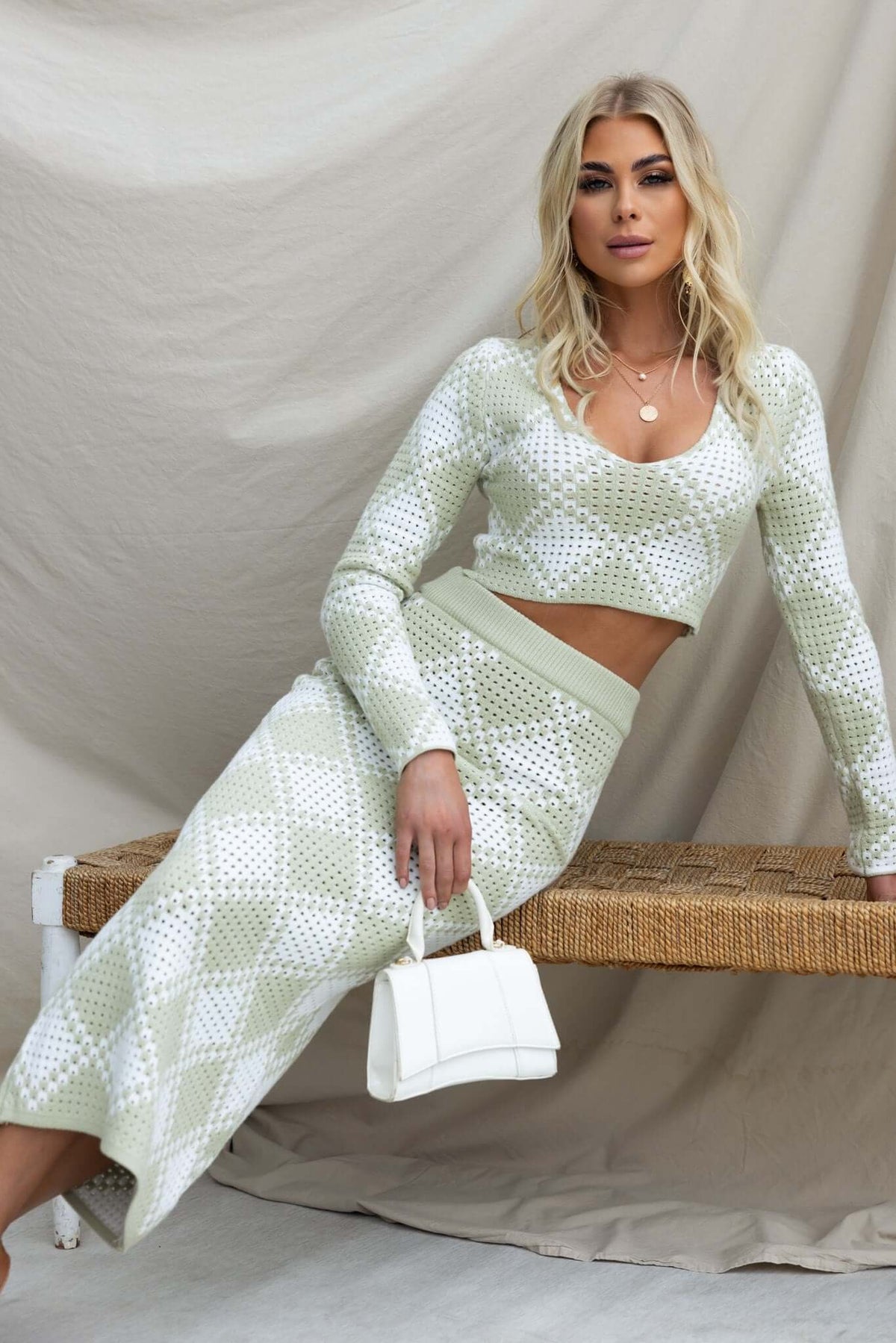 Model wearing the On My Own Set featuring a V-neckline, knit material, and a mid-high waist maxi skirt in green and white.