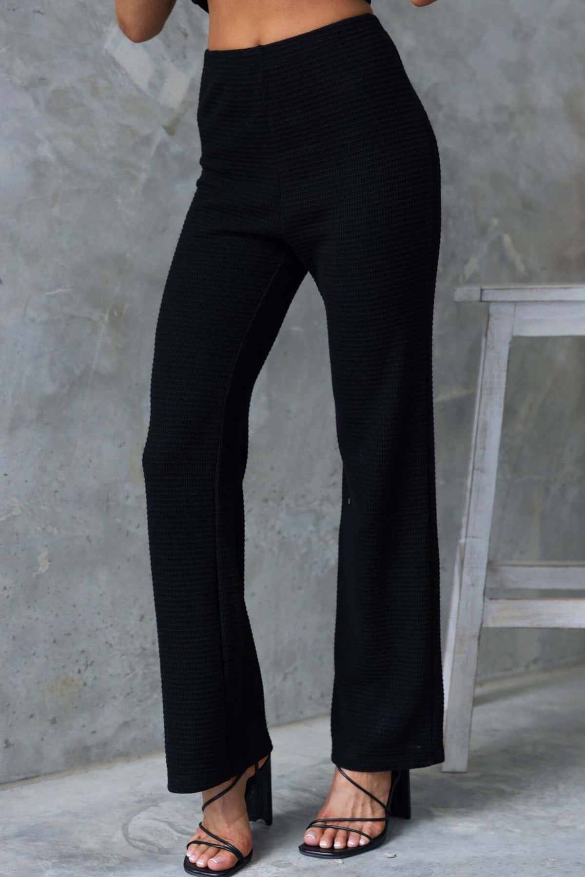 Xandra Pants in black with mid-high waist, elastic waistband, drop-crotch style, and stretchy knit material.