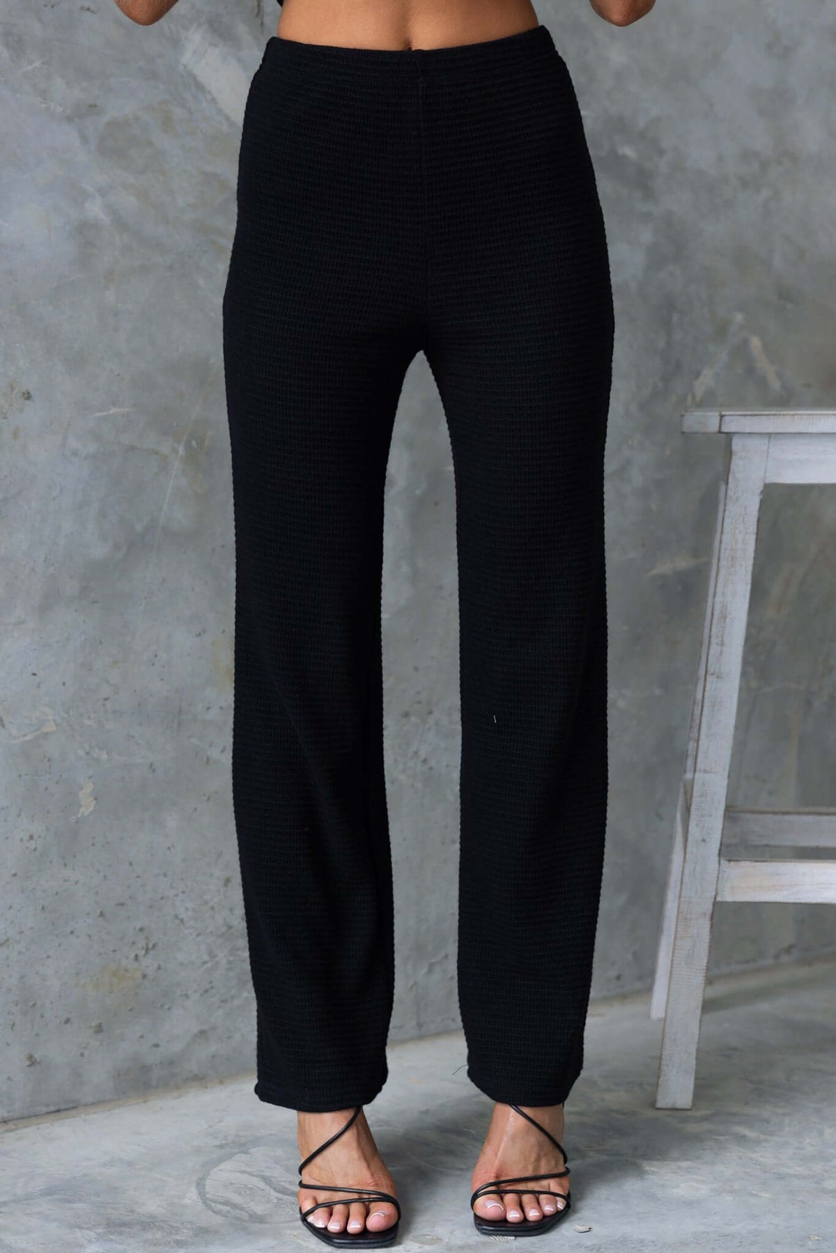 Xandra Pants in black, featuring a mid-high waist fit, drop-crotch style, and elastic waistband.