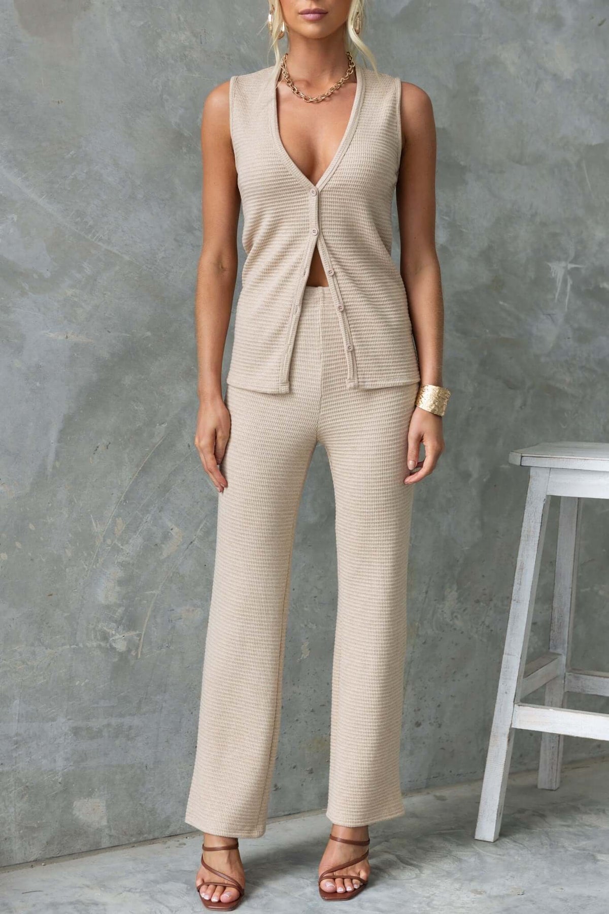 Model wearing Xandra Pants with mid-high waist and drop-crotch style in a neutral beige color.