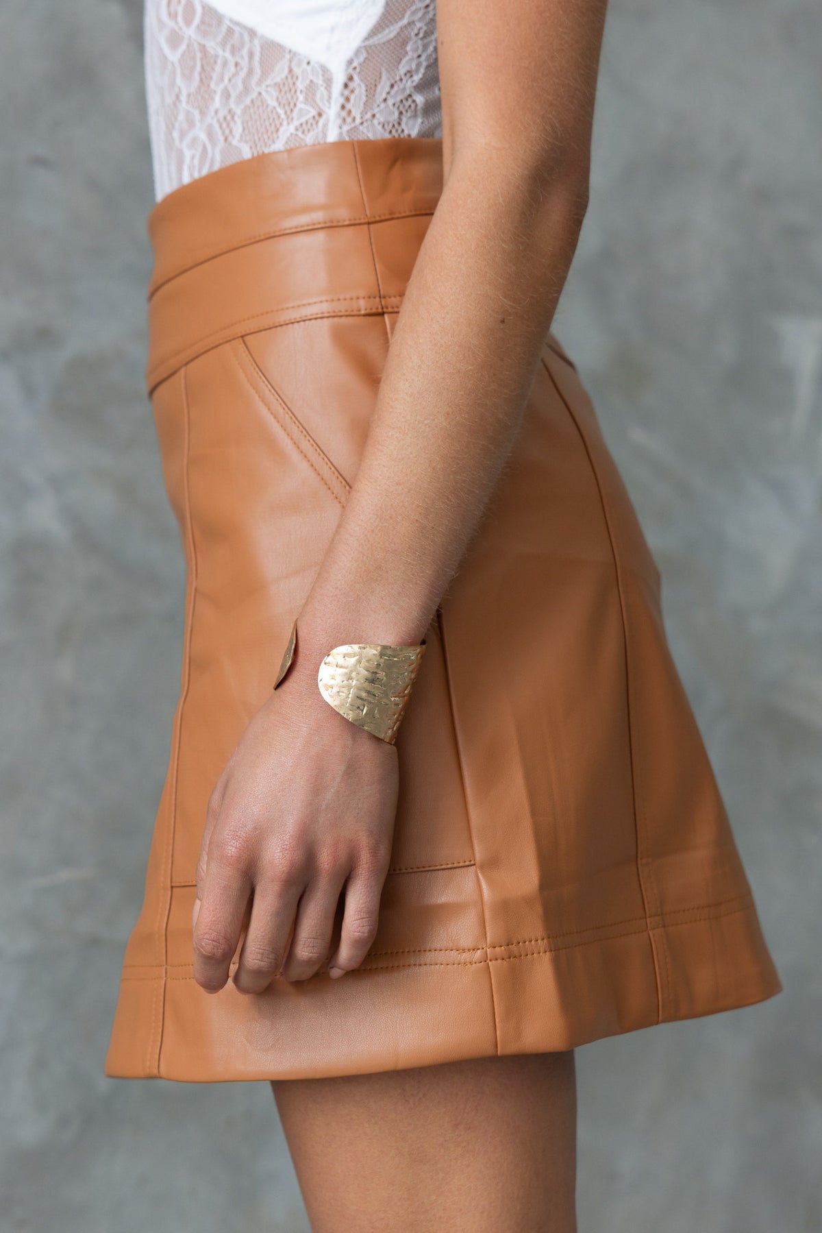 Side view of Inoe Skirt in faux leather, featuring a mid-high waist, pockets, and firm stretch fit.