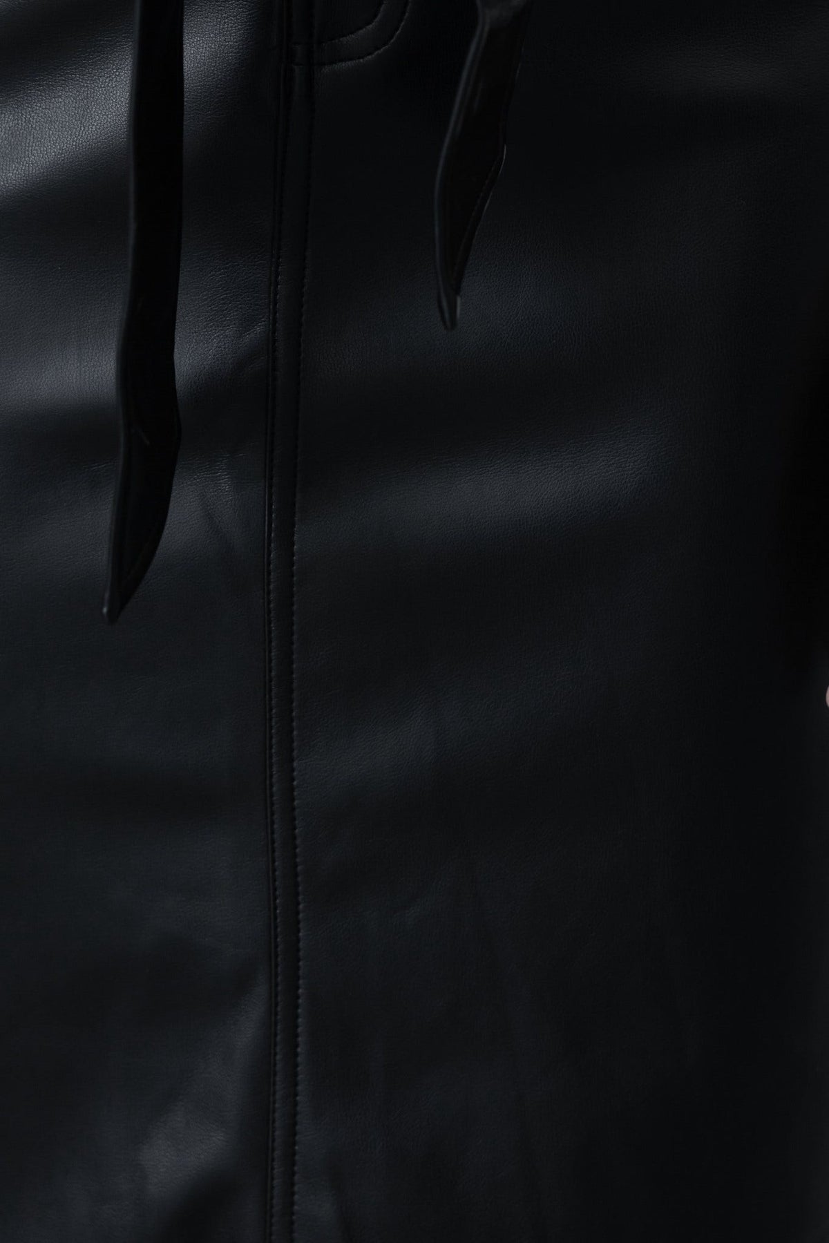 Close-up of the Nerida midi skirt in faux leather, featuring a tie detail and sleek black finish.