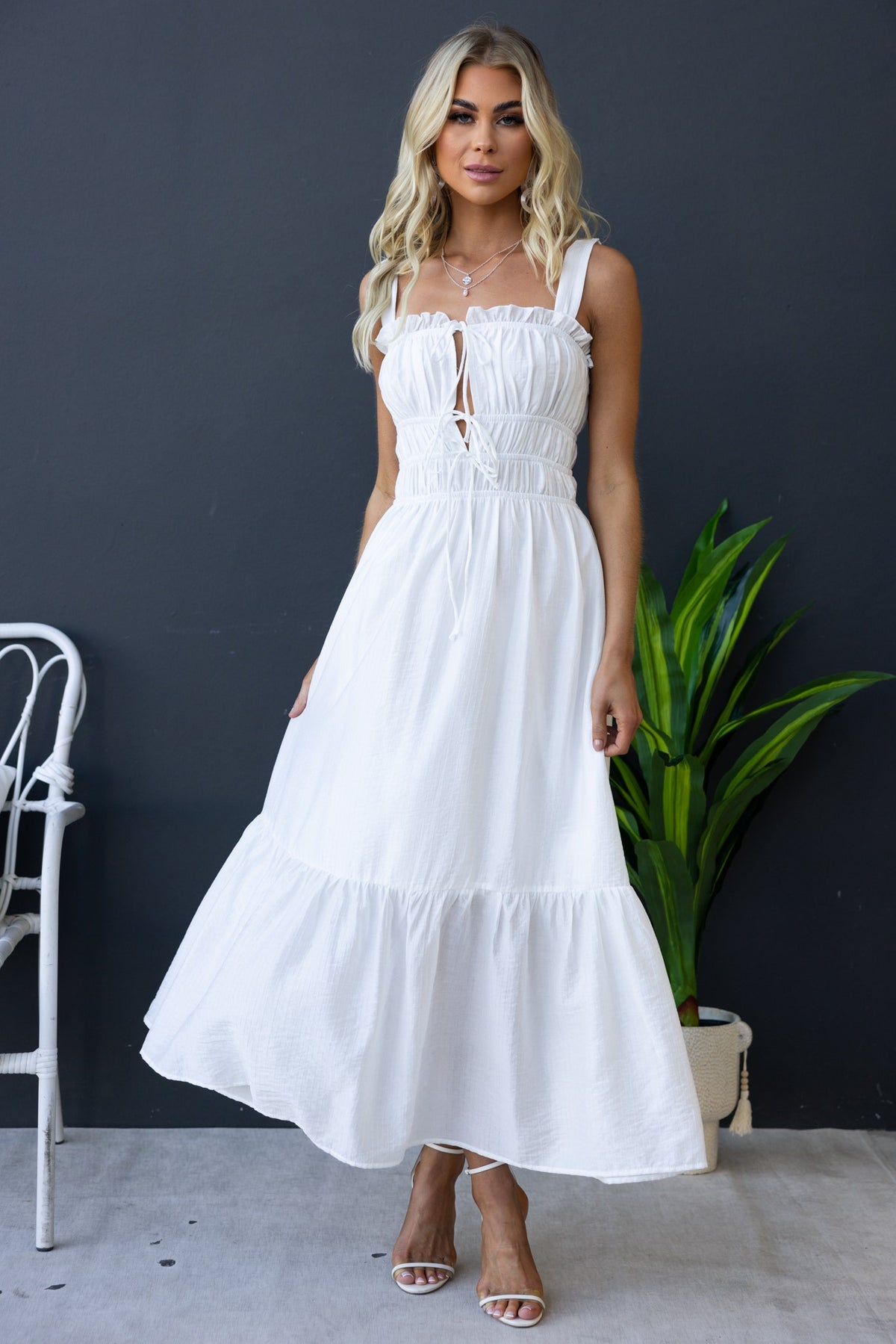 Shanina Midi Dress: Elegant white dress with textured fabric, elastic bodice, and tie details, perfect for warm weather.
