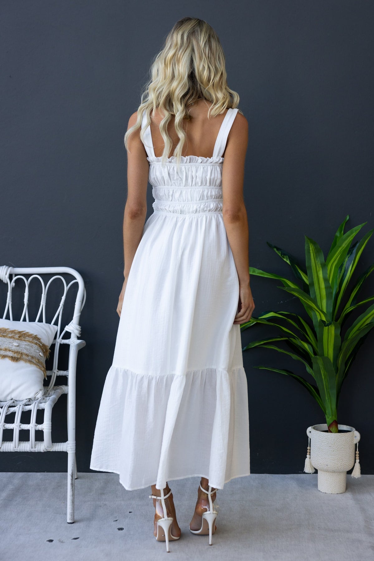 Back view of Shanina Midi Dress with elastic bodice and tie details, featuring a flowing white design and stylish strappy style.