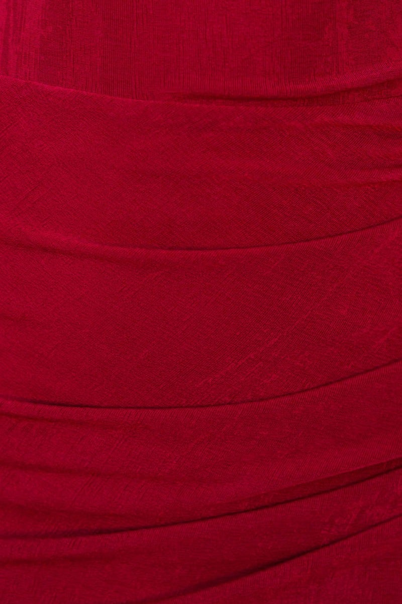 Close-up of ruching detail on a red bodycon maxi dress, highlighting its elegant and stretchy fabric.
