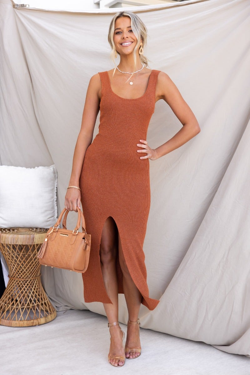 Ribbed knit Rata midi dress in rust color, featuring scoop neckline and front split, styled with an orange handbag.
