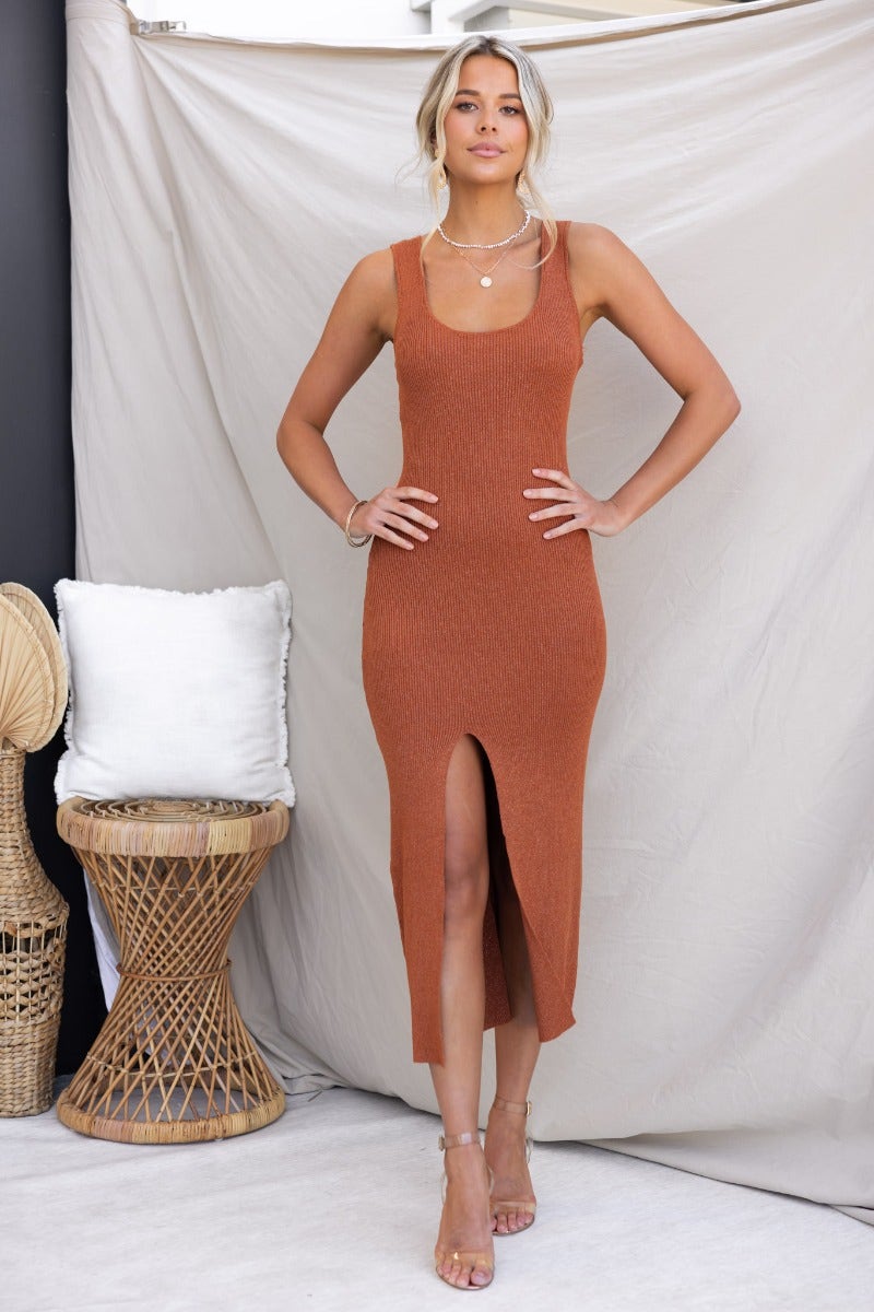 Rata Midi Dress in ribbed knit, featuring a scoop neckline and front split, styled with elegant accessories.