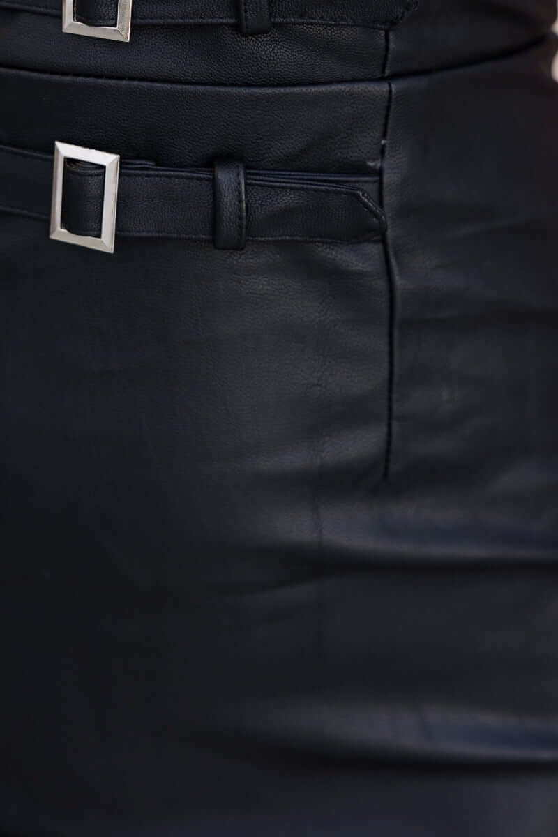Close-up of black faux leather dress featuring adjustable buckles and detail waist design.