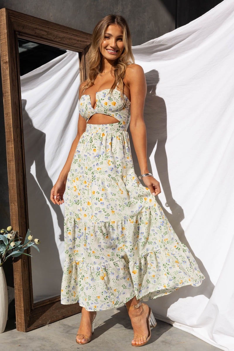 Model wearing Klarie Maxi Dress, a floral print maxi with cut-out waist, adjustable straps, and lined design.