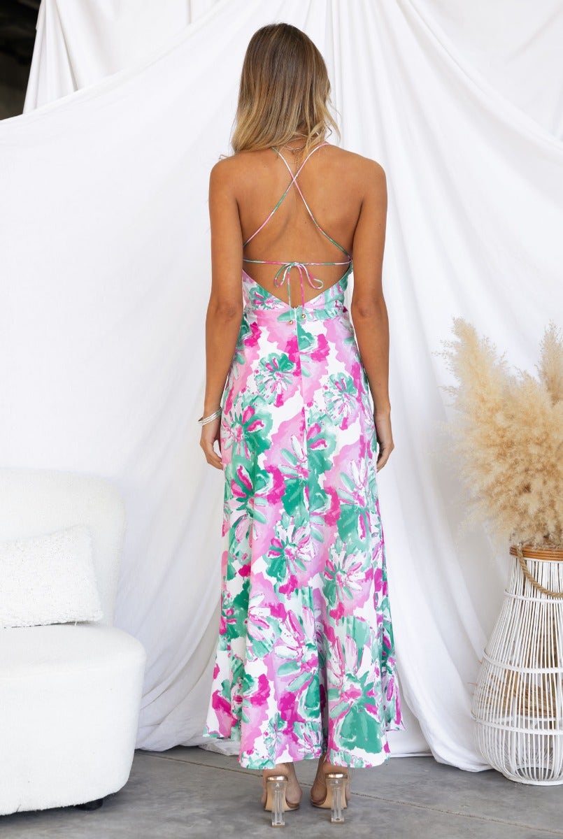 Back view of a woman in a floral print Tahnee maxi dress with adjustable tie straps, featuring a colorful design.