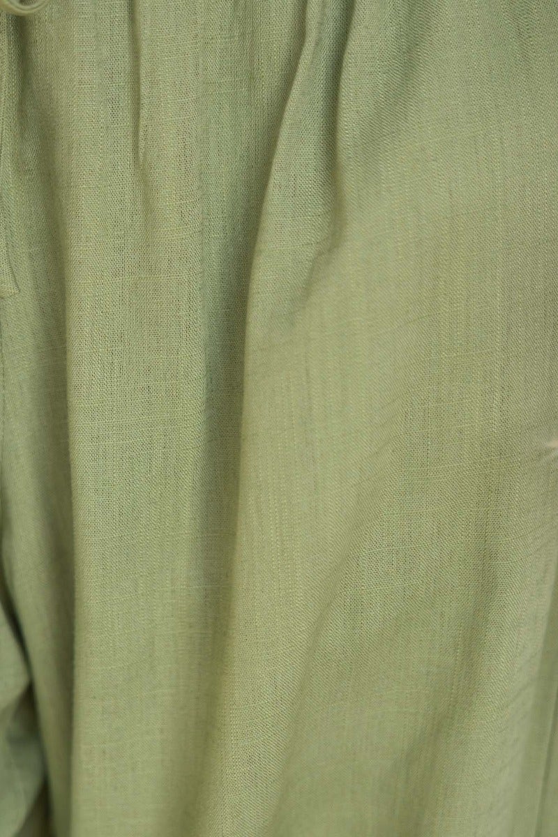 Close-up of soft green linen/cotton fabric of Karma Pants with textured finish and elastic waistband.