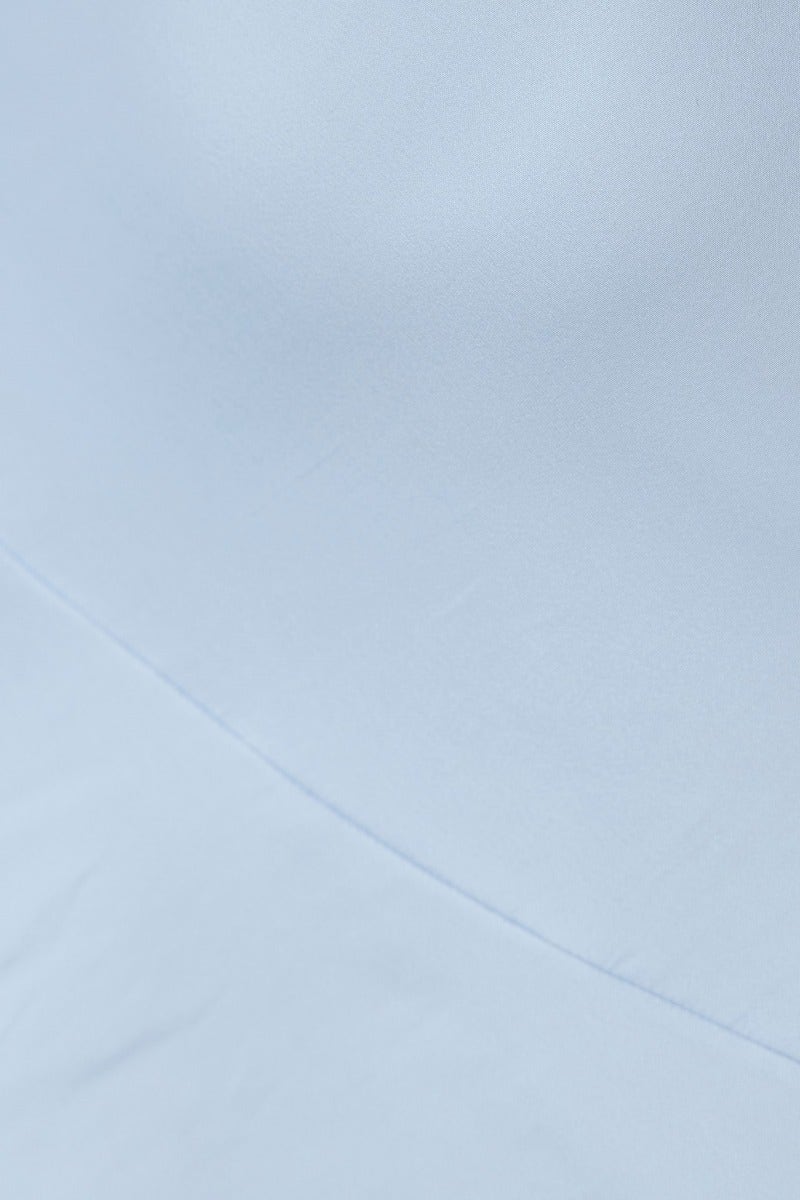 Close-up of the light blue fabric of the Arche Midi Dress showcasing its smooth texture and elegant design.