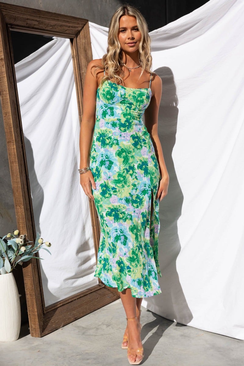 Floral print midi dress with adjustable straps, front split detail, and a stylish fit, showcased by a model.