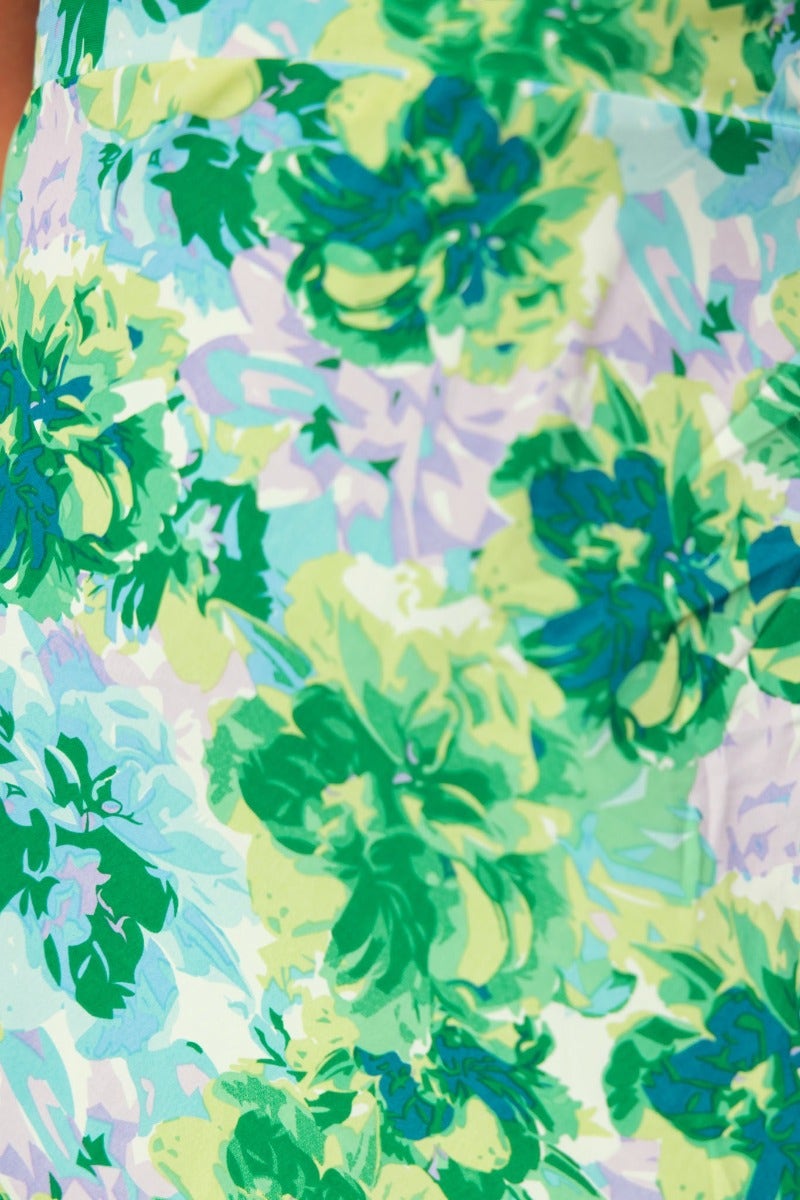 Close-up of a floral print fabric featuring vibrant green and pastel blossoms for a midi dress.