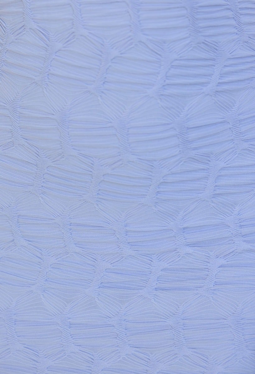 Close-up of textured fabric in soft blue, featuring intricate pattern and stretch for elegant maxi dress.