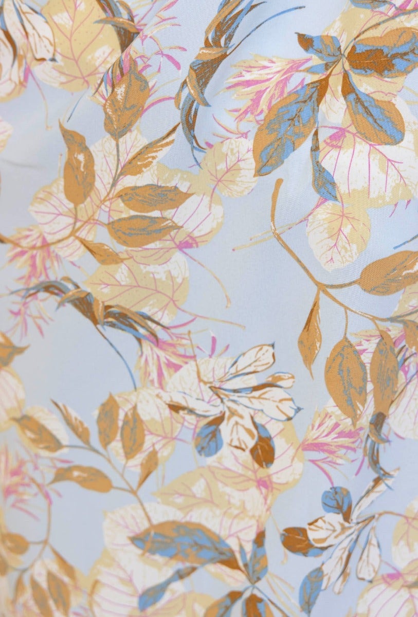 Floral print fabric showcasing intricate leaves and flowers in soft pastel colors, perfect for a summer maxi dress.