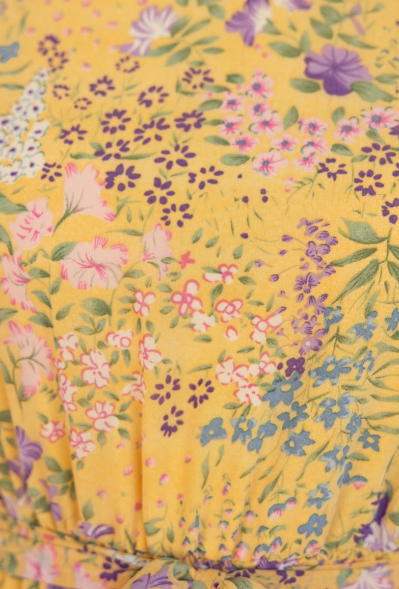 Close-up of the floral print on the Caprani dress featuring vibrant colors and a yellow background.