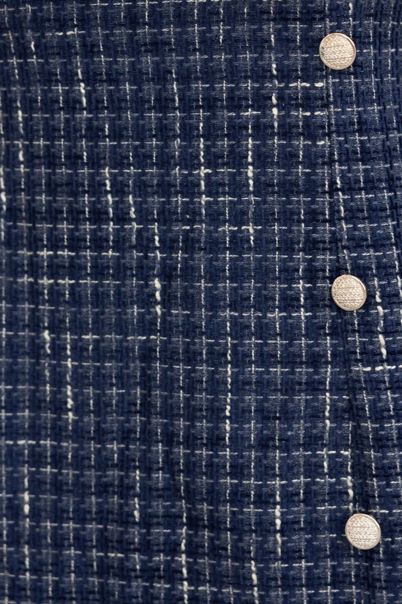 Close-up of the textured navy fabric of the Fine Line Midi Dress featuring gold button details.