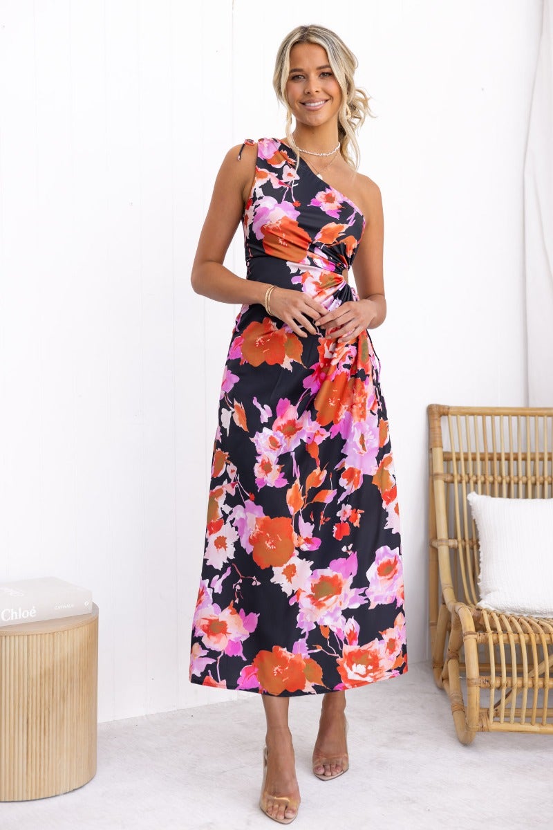 Black floral print Ronan maxi dress with one-shoulder neckline and adjustable ruching, styled elegantly.