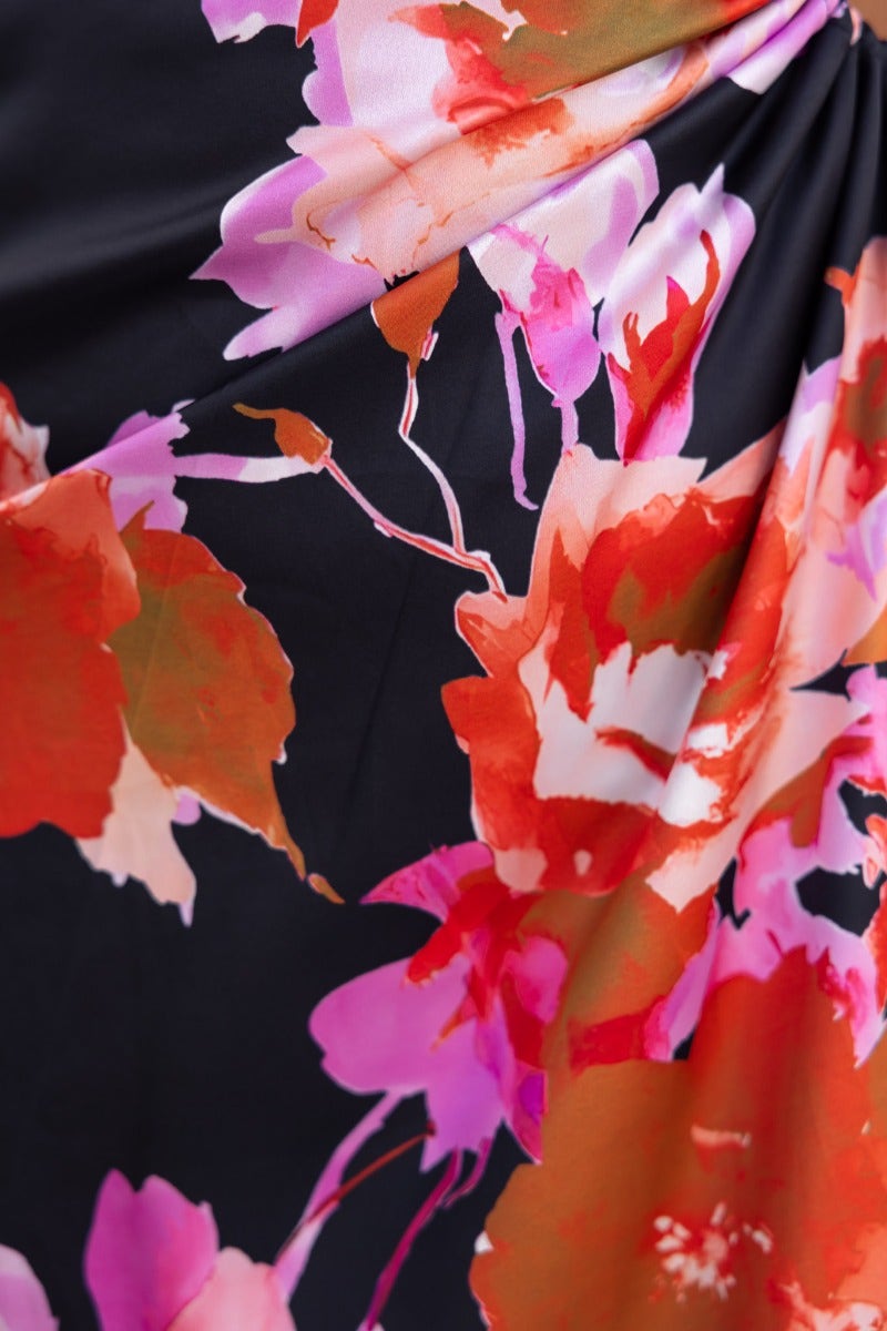 Close-up of black floral print fabric on Ronan Maxi Dress featuring vibrant pink and orange flowers.