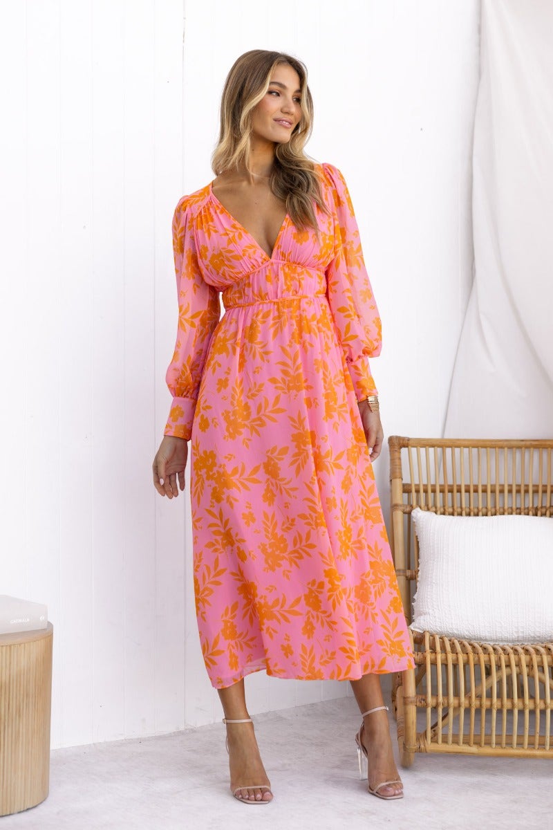 Jeanie Maxi Dress in floral print, featuring a V-neckline and elegant long sleeves, styled in vibrant pink and orange colors.