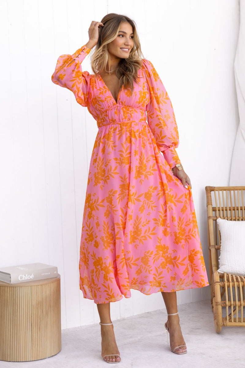 Model wearing Jeanie Maxi Dress in pink floral print, featuring V-neckline and puff sleeves for a stylish summer look.