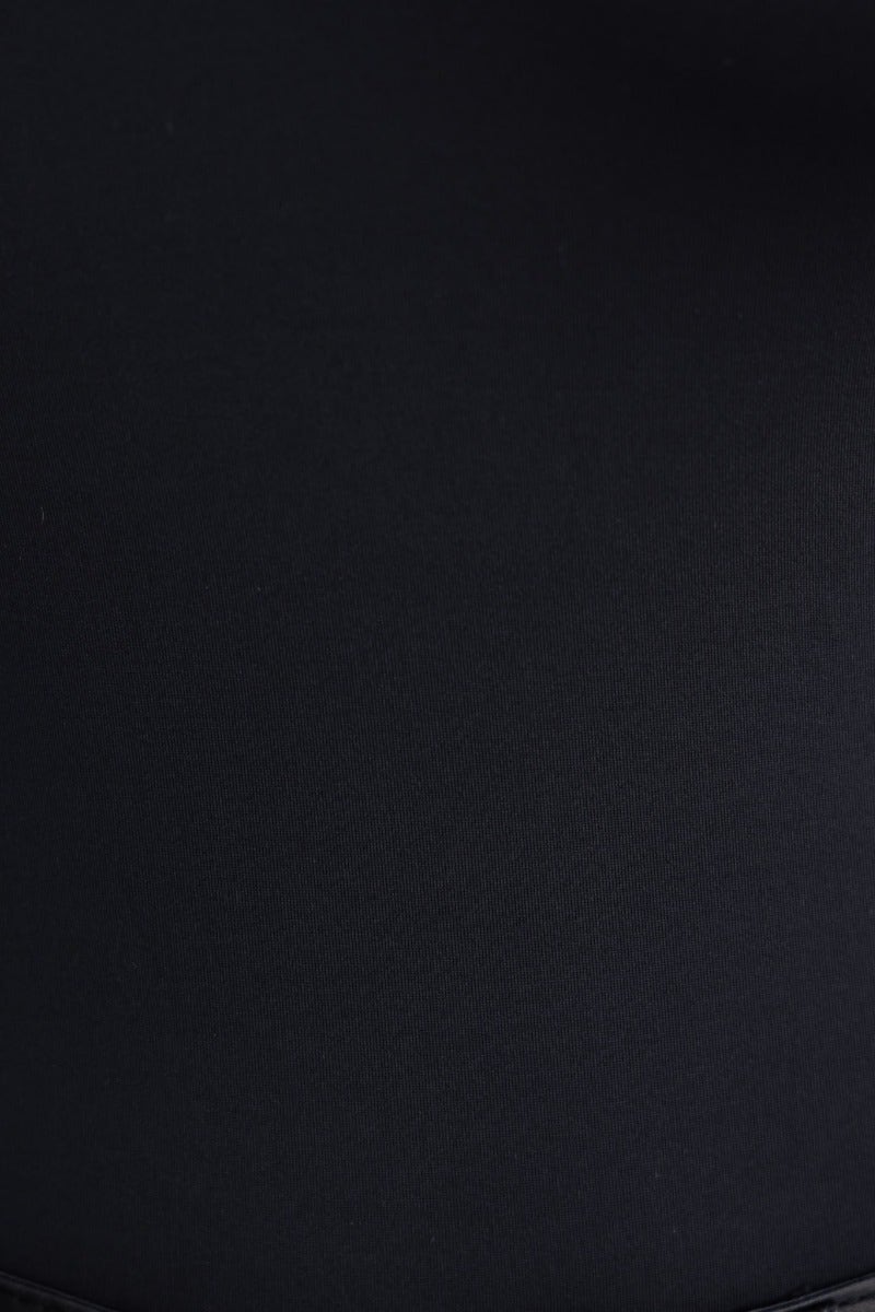 Close-up of the Leon Bodysuit in black showing smooth fabric texture and halter neckline.