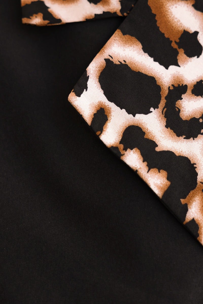 Detail of animal print fabric in browns and black on a lightweight trench coat.