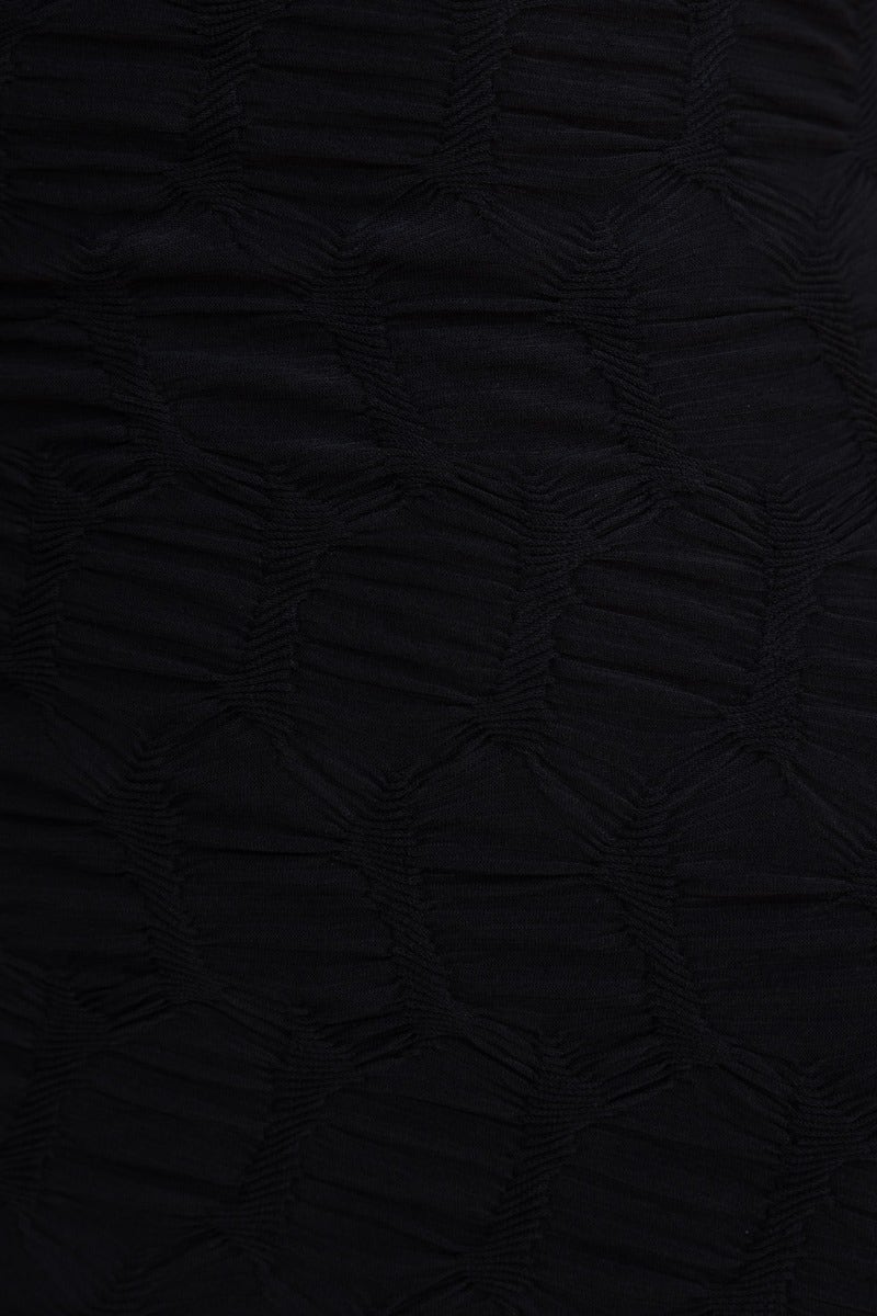 Close-up of black textured fabric used in the Over Again Maxi Dress, featuring a unique pattern and stretch material.