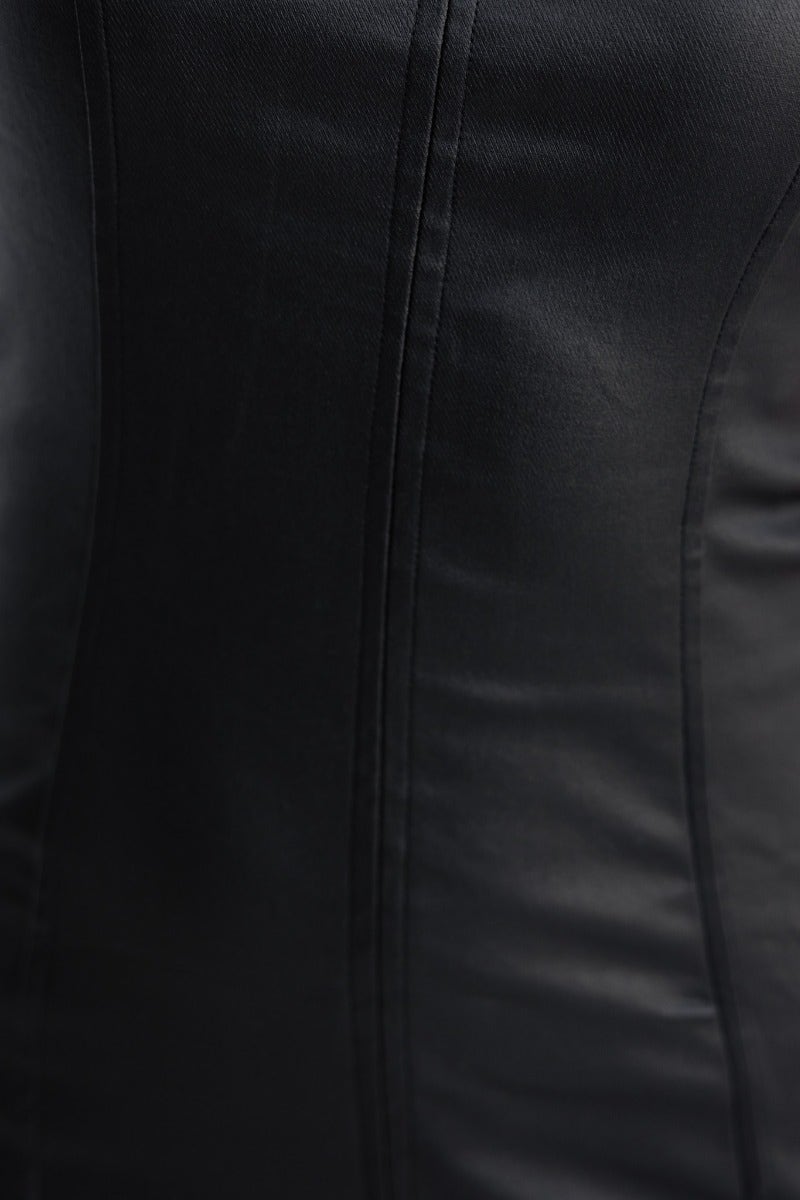 Close-up of black faux leather dress showcasing stretch material and seam details.