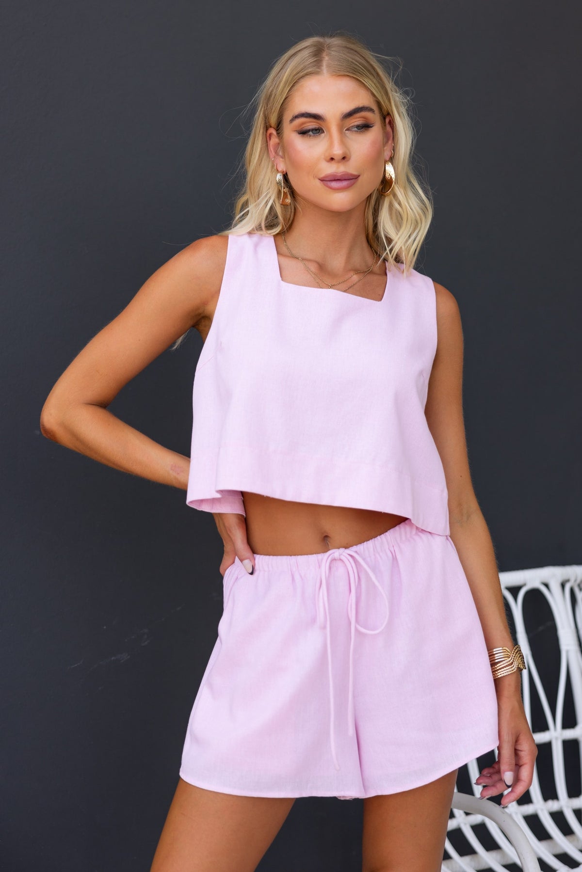 Tiann Top in light pink with square neckline and linen look, styled with matching shorts, exuding a relaxed summer vibe.