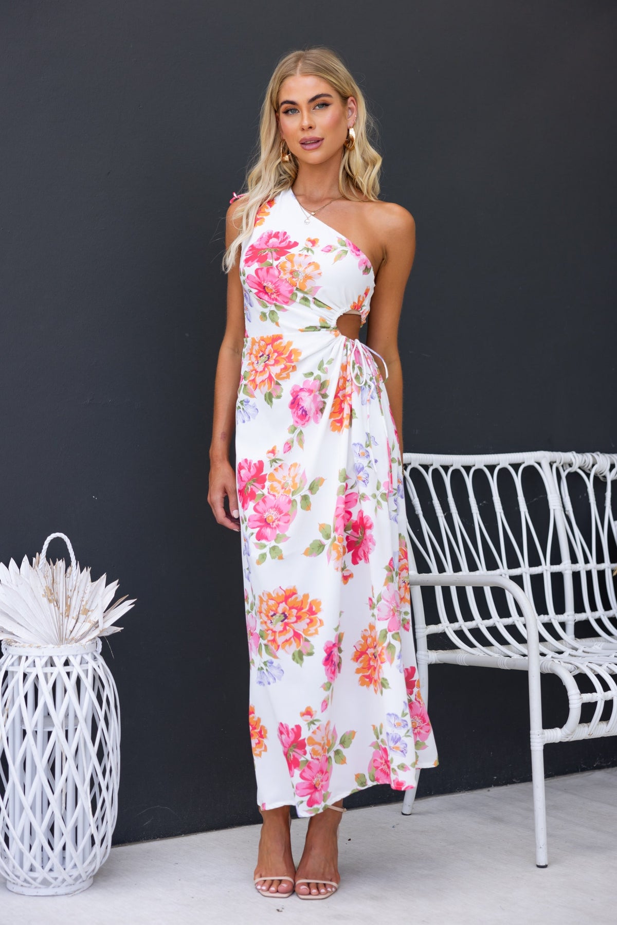 Floral print Ronan maxi dress featuring a one-shoulder neckline and side cut-out, styled with elegant accessories.