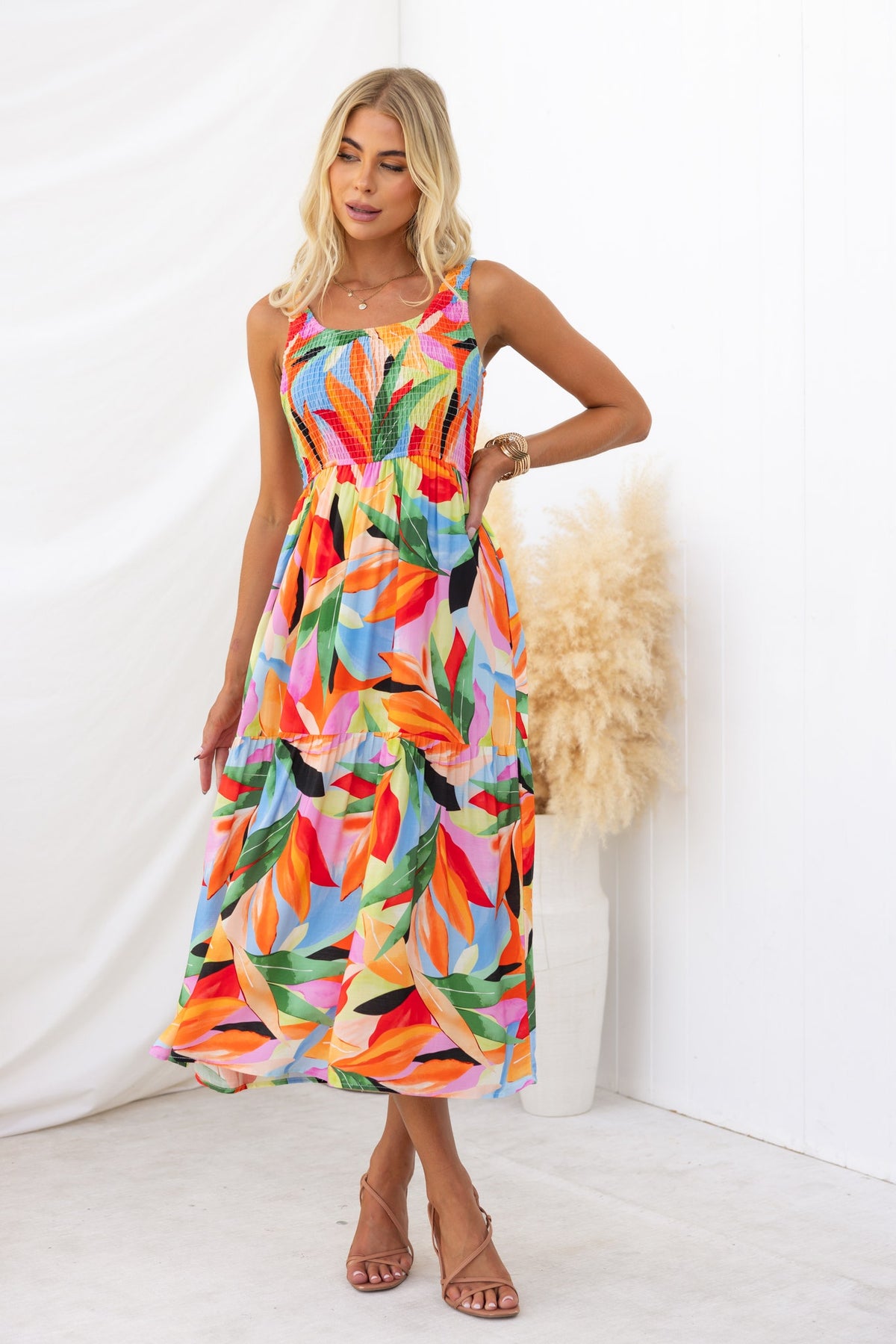Colorful floral midi dress with a round neckline and elastic bodice, styled with a model on a neutral background.