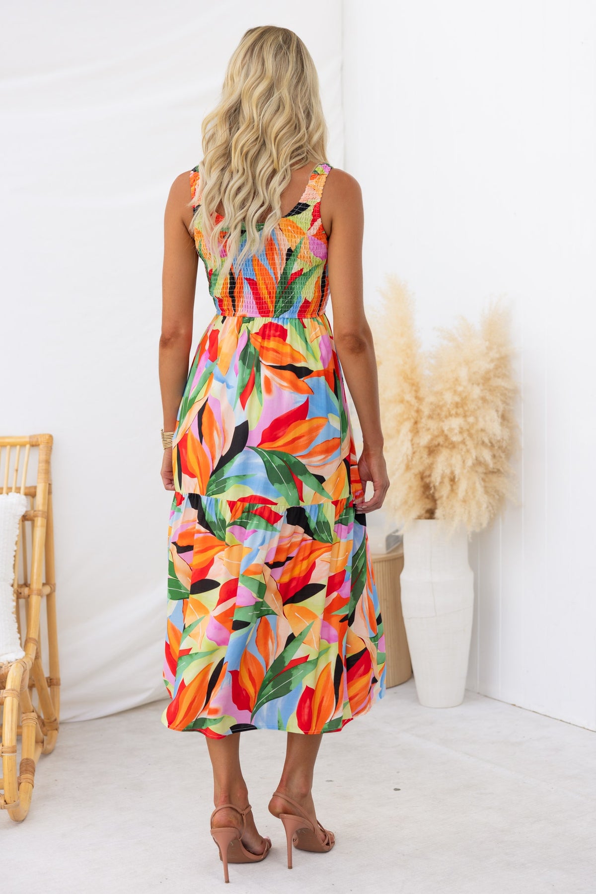 Model wearing a colorful floral print Lemi midi dress with a round neckline and elastic bodice.