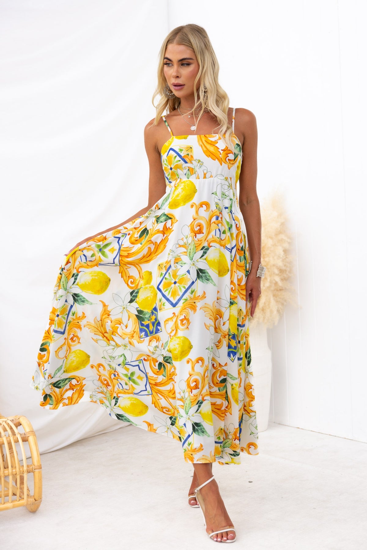 Model wearing a Summer Crush Maxi Dress with lemon and floral print, featuring adjustable straps and a flowing silhouette.