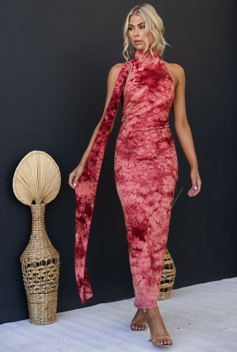 Model wearing a multi-colour Eyona maxi dress with high neckline and open back, styled against a minimalist background.