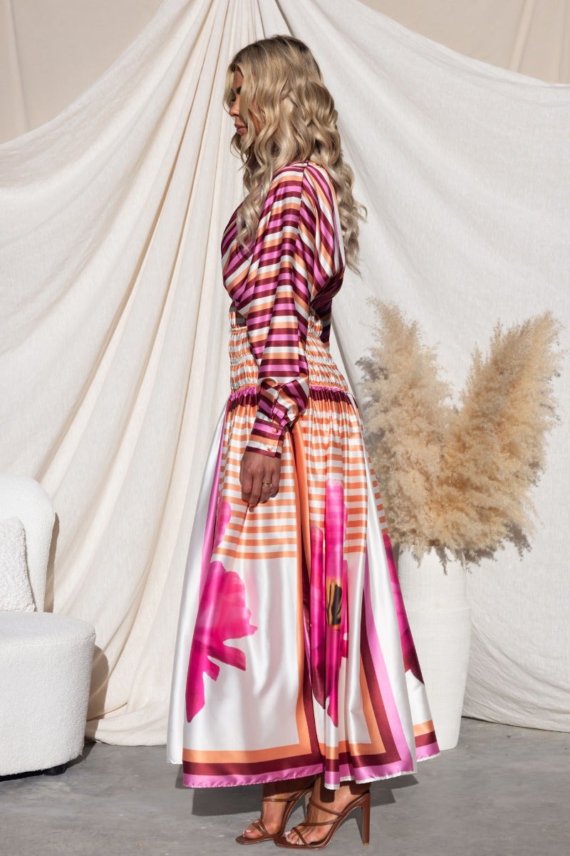 Model wearing Flaria Multi-colour Maxi Dress with V-neckline and batwing sleeves, showcasing vibrant floral patterns.